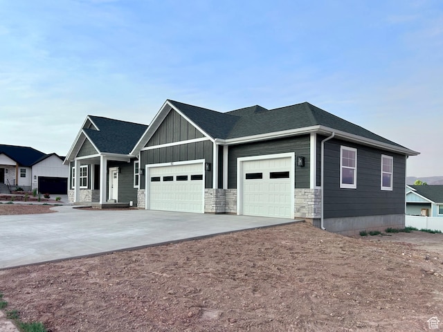 82 N 500 W, Gunnison, UT 84634 - view of front facade featuring an attached garage, driveway, stone siding, and board and batten siding
