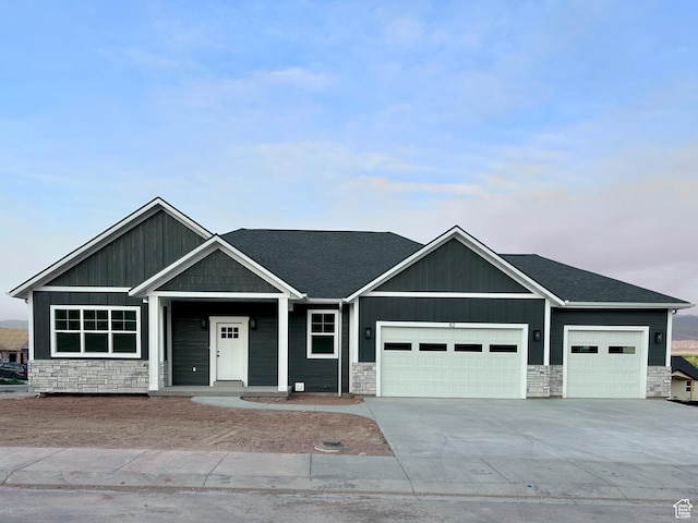 82 N 500 W, Gunnison, UT 84634 - view of front of house featuring stone siding, an attached garage, driveway, and a shingled roof