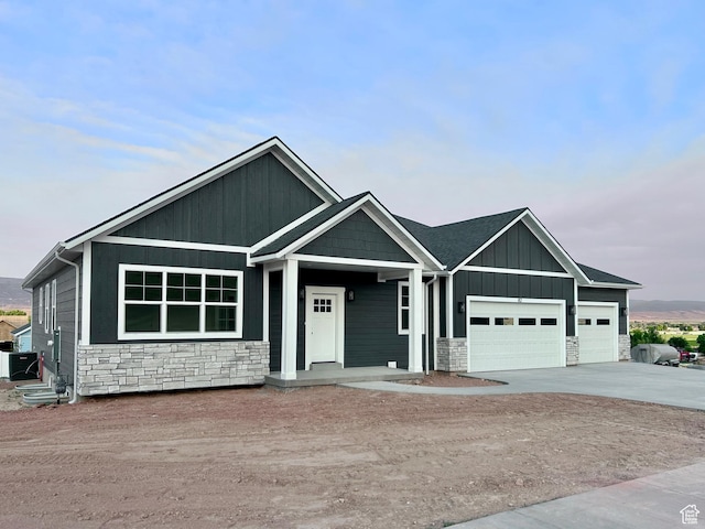 82 N 500 W, Gunnison, UT 84634 - view of front facade with stone siding, an attached garage, driveway, and board and batten siding