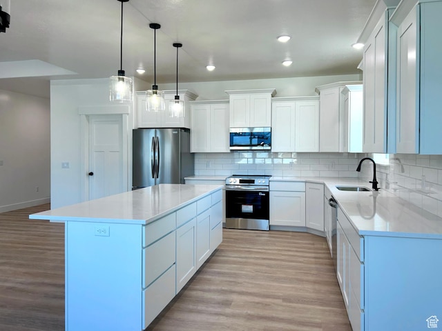 82 N 500 W, Gunnison, UT 84634 - kitchen featuring appliances with stainless steel finishes, light wood-type flooring, backsplash, a center island, and recessed lighting