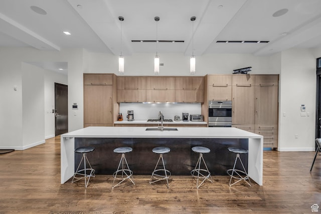 333 Main St Unit 10, Park City, UT 84060 - kitchen featuring modern cabinets, dark wood finished floors, backsplash, a large island with sink, and light countertops