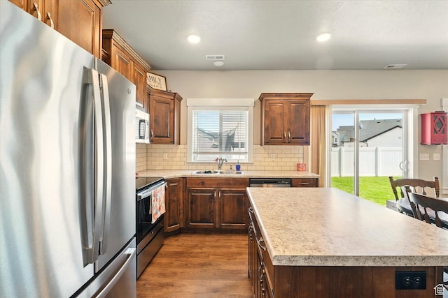 1469 W 2200 S, Wellsville, UT 84339 - kitchen with appliances with stainless steel finishes, tasteful backsplash, dark wood-style flooring, a center island, and recessed lighting