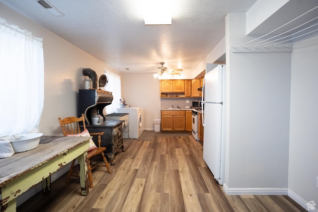 1075 E 2600 N, North Ogden, UT 84414 - kitchen with white appliances, a wood stove, light wood-style flooring, washer / clothes dryer, and light countertops