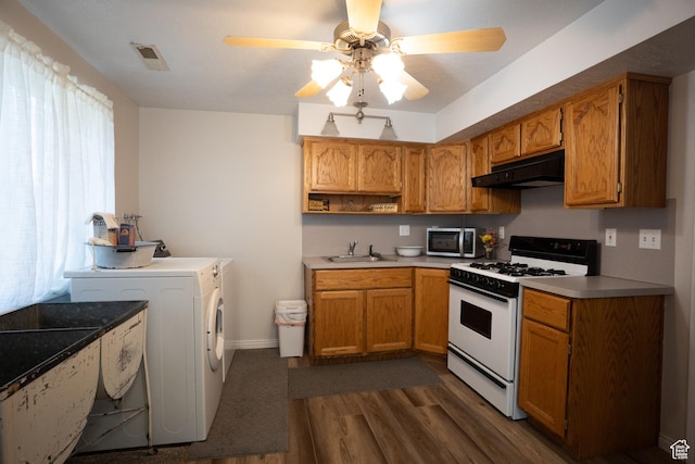 1075 E 2600 N, North Ogden, UT 84414 - kitchen featuring white gas stove, stainless steel microwave, under cabinet range hood, washer / clothes dryer, and dark wood-type flooring