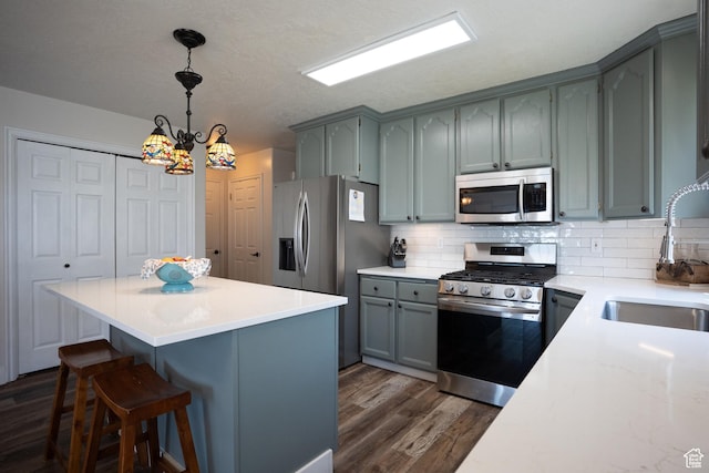 1075 E 2600 N, North Ogden, UT 84414 - kitchen featuring stainless steel appliances, dark wood finished floors, backsplash, and a center island