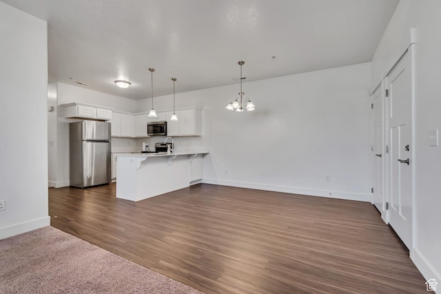 776 N 260 W, Vineyard, UT 84059 - kitchen with appliances with stainless steel finishes, a peninsula, a chandelier, a kitchen breakfast bar, and light countertops