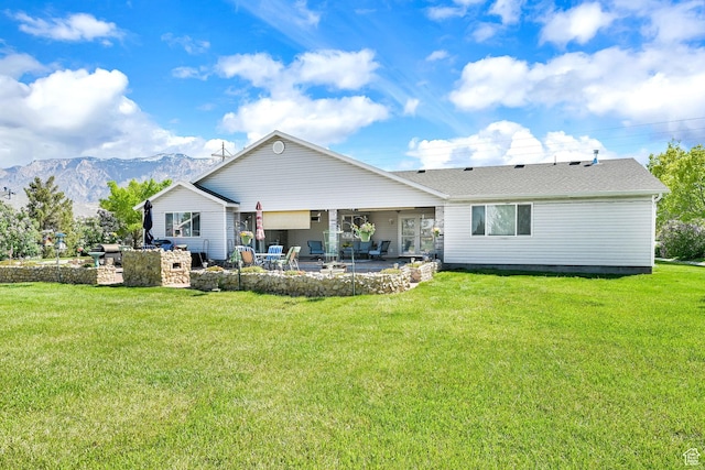 3139 N Pelican Dr, Farr West, UT 84404 - rear view of property with a patio area, a lawn, and a mountain view