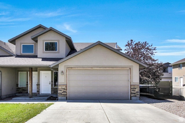 429 W 350 N Unit 4, Tremonton, UT 84337 - view of front facade with stucco siding, stone siding, driveway, roof with shingles, and a garage