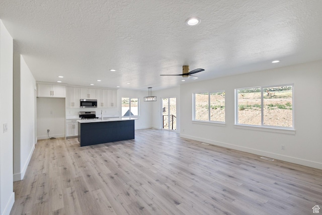 1536 N 300 E Unit 49, Nephi, UT 84648 - unfurnished living room with light wood-style flooring, recessed lighting, a textured ceiling, and a ceiling fan