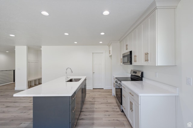 1536 N 300 E Unit 49, Nephi, UT 84648 - kitchen with stainless steel appliances, light wood-style floors, white cabinetry, a kitchen island with sink, and recessed lighting