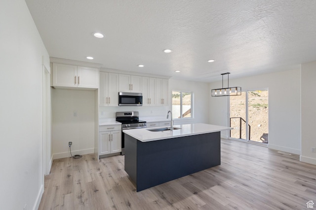 1536 N 300 E Unit 49, Nephi, UT 84648 - kitchen with appliances with stainless steel finishes, white cabinets, light wood finished floors, light countertops, and recessed lighting