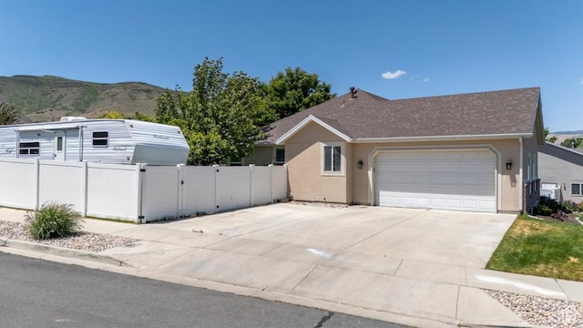 5183 W Heartland Cv, Herriman, UT 84096 - view of side of home featuring a mountain view, a garage, concrete driveway, and stucco siding