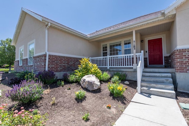 5183 W Heartland Cv, Herriman, UT 84096 - entrance to property featuring brick siding, stucco siding, and a porch