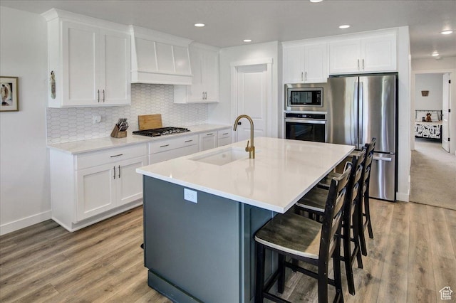 2106 W 2000 N, Farr West, UT 84404 - kitchen with stainless steel appliances, custom exhaust hood, white cabinets, light wood-type flooring, and recessed lighting