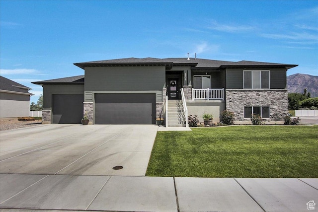2106 W 2000 N, Farr West, UT 84404 - prairie-style home with stone siding, an attached garage, a front lawn, driveway, and a mountain view