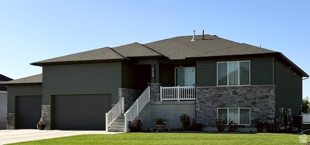 2106 W 2000 N, Farr West, UT 84404 - prairie-style house featuring stone siding, driveway, an attached garage, a front lawn, and a porch