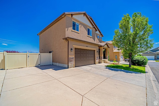 6563 S Days End Ct, West Jordan, UT 84081 - view of front of home featuring a gate, a garage, driveway, stucco siding, and stone siding
