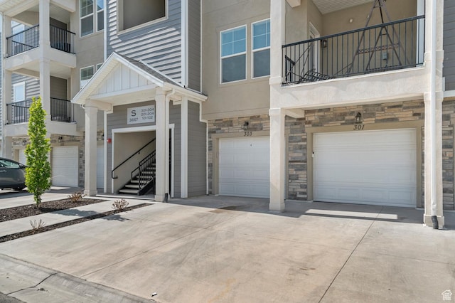 3667 W Canyon Falls Dr Unit S301, Lehi, UT 84043 - doorway to property with stone siding, an attached garage, driveway, and board and batten siding