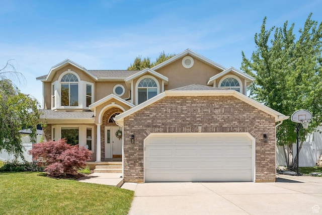 2401 N 1400 E, Layton, UT 84040 - traditional home featuring an attached garage, concrete driveway, a front lawn, stucco siding, and brick siding