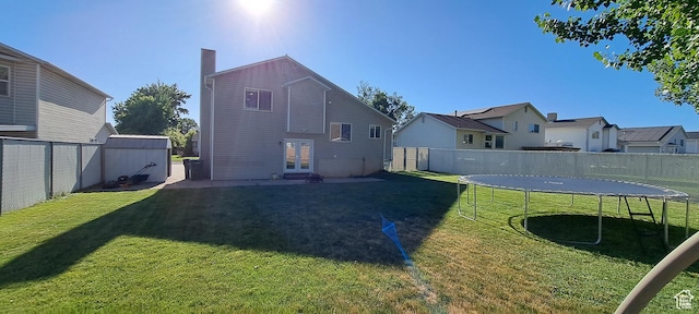 5256 S 3400 W, Roy, UT 84067 - back of property featuring a trampoline, french doors, a fenced backyard, and a chimney