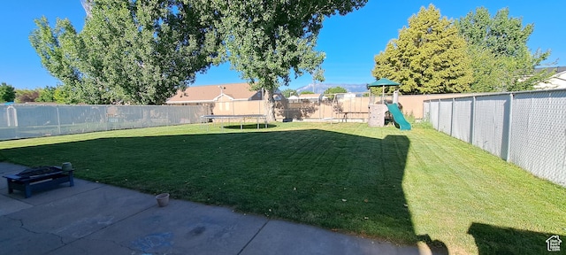 5256 S 3400 W, Roy, UT 84067 - fenced backyard with a trampoline, a playground, and a patio area