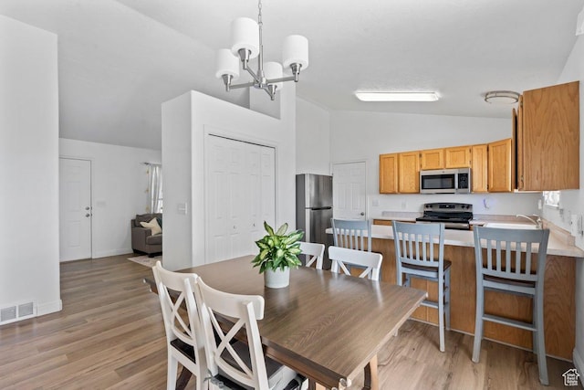 2144 E Easter Dr, Eagle Mountain, UT 84005 - dining space featuring lofted ceiling, a chandelier, and light wood-style floors
