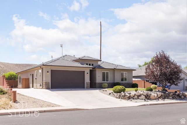 943 N 100 W, Hurricane, UT 84737 - view of front of property with stone siding, a garage, concrete driveway, and stucco siding