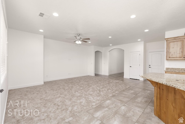 943 N 100 W, Hurricane, UT 84737 - unfurnished living room with arched walkways, recessed lighting, ceiling fan, light tile patterned flooring, and light carpet