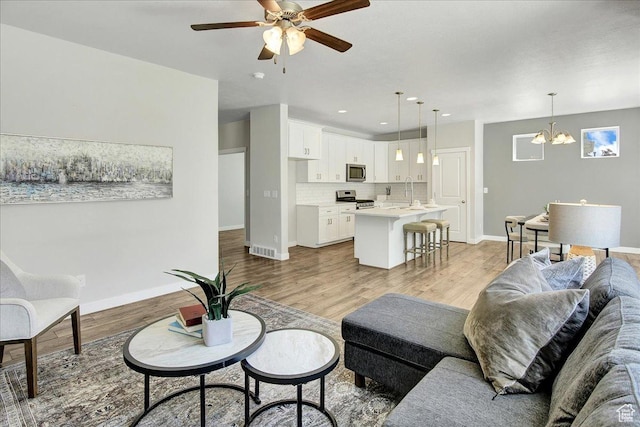 12232 S Sigmon Ln, Herriman, UT 84096 - living room with a ceiling fan, light wood-style floors, a chandelier, and recessed lighting
