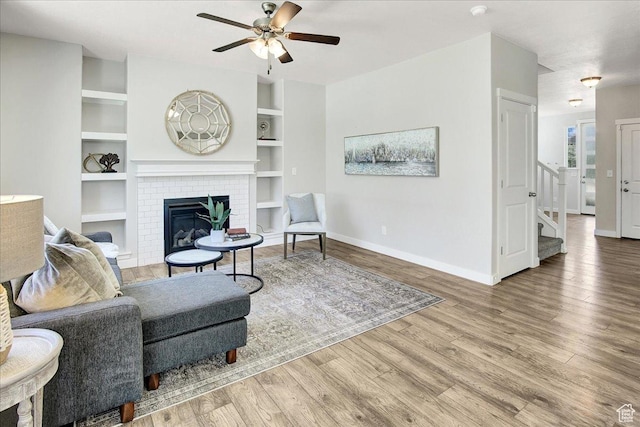 12232 S Sigmon Ln, Herriman, UT 84096 - living area with a ceiling fan, wood finished floors, stairway, and a brick fireplace
