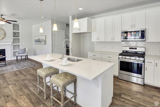 12232 S Sigmon Ln, Herriman, UT 84096 - kitchen with appliances with stainless steel finishes, dark wood-style flooring, white cabinets, decorative backsplash, and recessed lighting