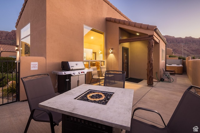 3686 S Spanish Valley Dr Unit Y1, Moab, UT 84532 - patio terrace at dusk featuring an outdoor fire pit, grilling area, and a patio