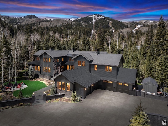 2475 W White Pine Ln Unit 11, Park City, UT 84060 - view of front facade with a mountain view, a view of trees, driveway, an attached garage, and a shingled roof
