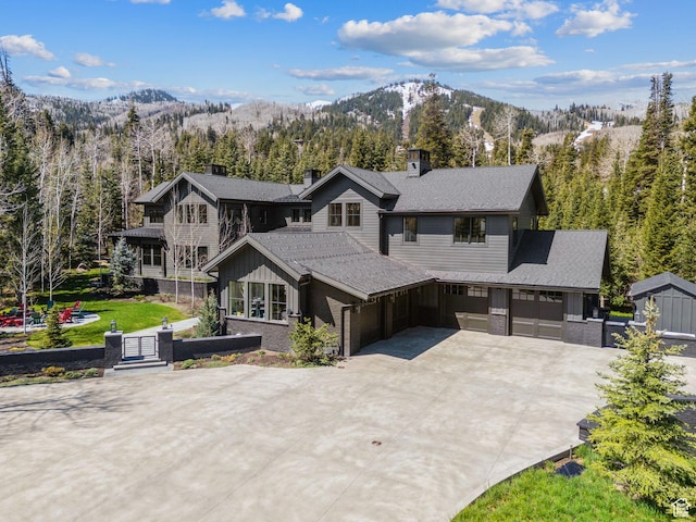 2475 W White Pine Ln Unit 11, Park City, UT 84060 - view of front facade with driveway, a chimney, a mountain view, an attached garage, and a forest view