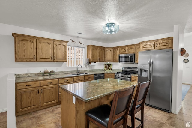 504 E Telegraph St Unit 89, Washington, UT 84780 - kitchen with stainless steel appliances, brown cabinets, a kitchen island, a breakfast bar area, and stone counters