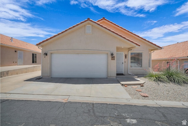 504 E Telegraph St Unit 89, Washington, UT 84780 - mediterranean / spanish-style home featuring a tiled roof, stucco siding, an attached garage, and driveway