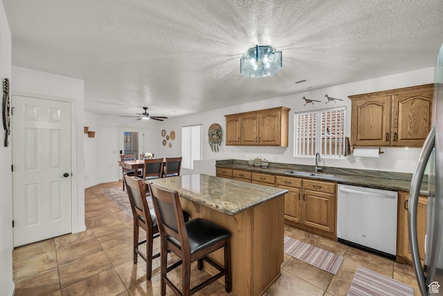 504 E Telegraph St Unit 89, Washington, UT 84780 - kitchen featuring stainless steel appliances, brown cabinets, a center island, a kitchen breakfast bar, and dark stone countertops