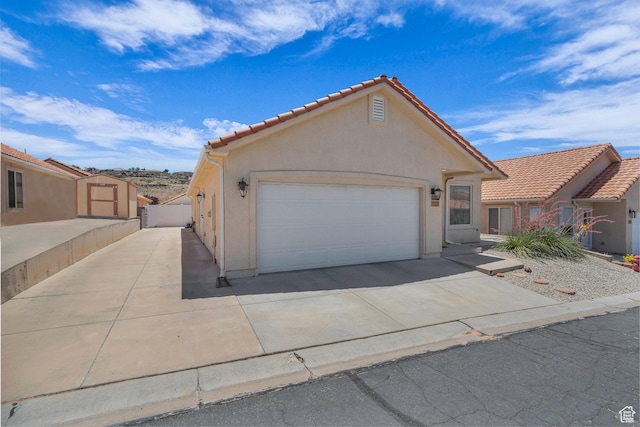 504 E Telegraph St Unit 89, Washington, UT 84780 - view of front of property with driveway, an attached garage, stucco siding, and a tiled roof