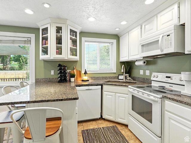 2802 W 4875 S, Roy, UT 84067 - kitchen featuring white appliances, a peninsula, white cabinets, glass insert cabinets, and light tile patterned floors