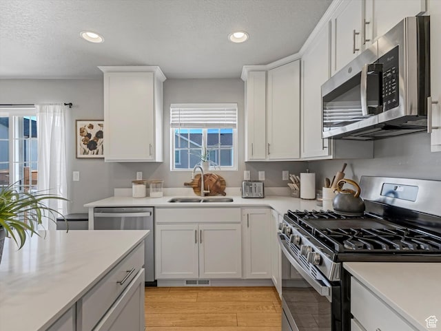 406 W Tesla Ct, Grantsville, UT 84029 - kitchen featuring stainless steel appliances, plenty of natural light, recessed lighting, light countertops, and white cabinetry