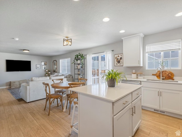 406 W Tesla Ct, Grantsville, UT 84029 - kitchen featuring light wood-style flooring, plenty of natural light, light countertops, white cabinets, and recessed lighting