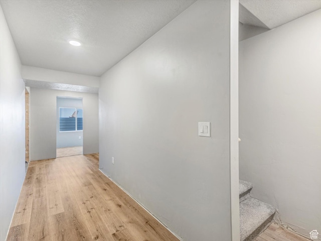 406 W Tesla Ct, Grantsville, UT 84029 - hall with light wood-type flooring, a textured ceiling, and stairway
