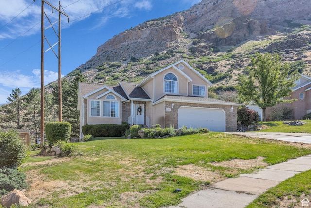 1156 E Avalon Hills Dr N, Ogden, UT 84404 - traditional-style home featuring an attached garage, a mountain view, a front lawn, and brick siding