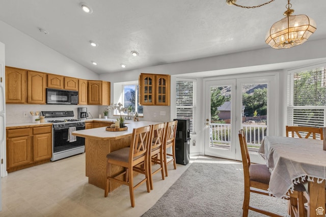 1156 E Avalon Hills Dr N, Ogden, UT 84404 - kitchen with black microwave, white gas range, lofted ceiling, a kitchen bar, and glass insert cabinets