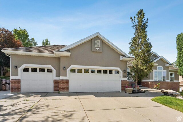 1036 E Fairway Dr, North Salt Lake, UT 84054 - view of front of property featuring brick siding, a garage, driveway, and stucco siding