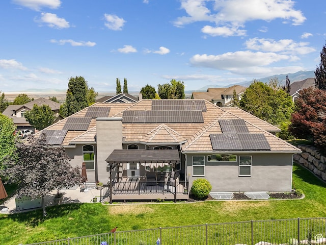 1036 E Fairway Dr, North Salt Lake, UT 84054 - back of house with a fenced backyard, stucco siding, roof mounted solar panels, and a tile roof