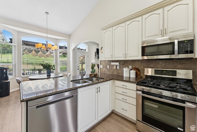 1036 E Fairway Dr, North Salt Lake, UT 84054 - kitchen with stainless steel appliances, lofted ceiling, a peninsula, tasteful backsplash, and light wood-type flooring