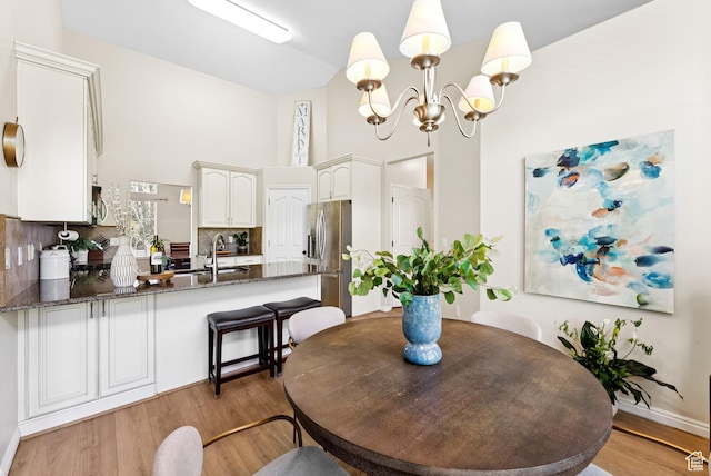 1036 E Fairway Dr, North Salt Lake, UT 84054 - dining space featuring a chandelier, light wood-style flooring, and high vaulted ceiling