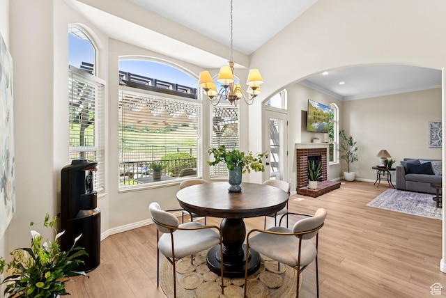1036 E Fairway Dr, North Salt Lake, UT 84054 - dining area featuring arched walkways, a chandelier, plenty of natural light, light wood-type flooring, and ornamental molding