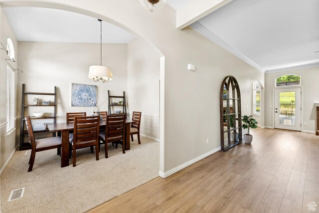 1036 E Fairway Dr, North Salt Lake, UT 84054 - dining room with arched walkways, wood finished floors, crown molding, and a chandelier